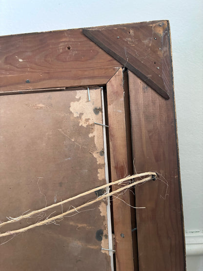 Close-up of a wooden frame with a string attached, on a light-colored wall.