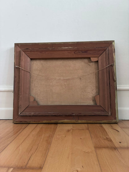 Wooden picture frame on a wooden floor with a white wall background