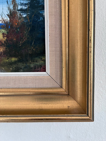 Close-up of a painting with a gold frame on a white wall