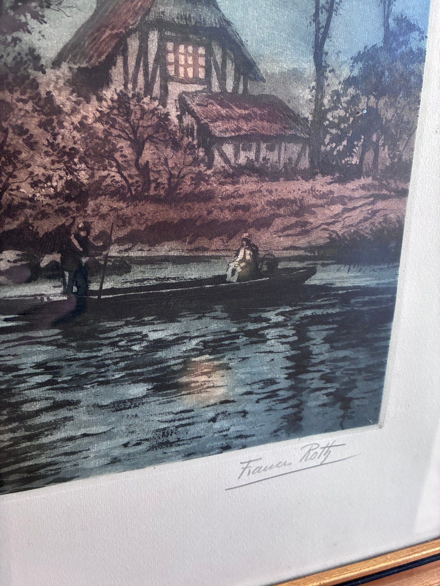 A framed or mounted  vintage art print showing a moody outdoor scene with a house, trees, and a reflective body of water. The vintage print has a visible signature in the upper right and is photographed against a light neutral background.